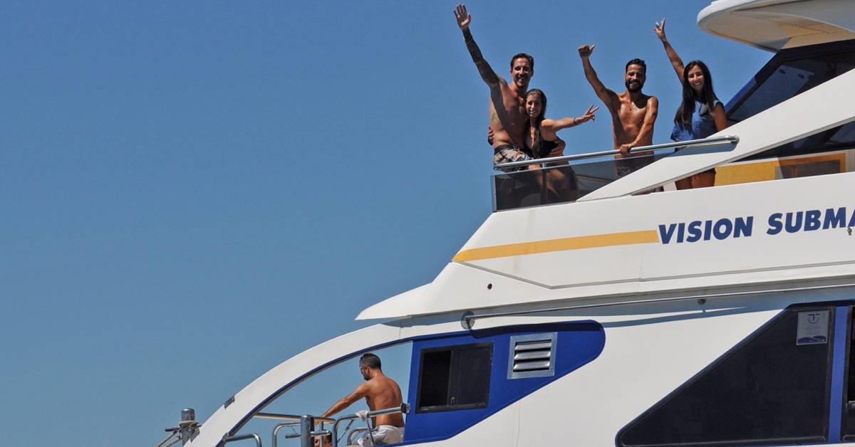 Pasajeros saludando y disfrutando en la cubierta superior del catamarán Restaurante Marinero