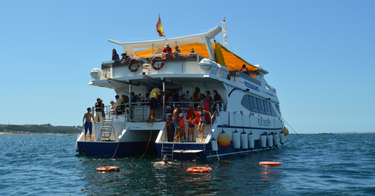 Popa del catamarán con plataforma de baño y escaleras de acceso al mar, playa de As Pipas.